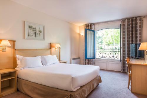 Cette chambre comprend un grand lit et une fenêtre. dans l'établissement Résidence du Grand Hôtel, au Plessis-Robinson