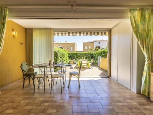 Une porte ouverte s'ouvre sur une terrasse avec une table et des chaises. dans l'établissement Apartment Les Maisons sur la Plage-2 by Interhome, au Cap d'Agde