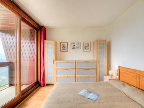 une chambre avec un lit et une grande fenêtre dans l'établissement Apartment Pegase Phenix-35 by Interhome, au Corbier