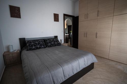 a bedroom with a large bed and wooden cabinets at Τα ανετα διαμμερισματα του Λεκα Α2 in Zakharo