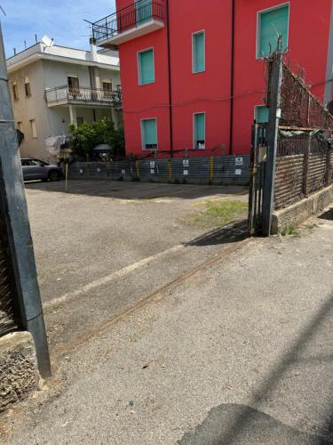 an empty parking lot with a red building at B&B al Palazzo in Agropoli