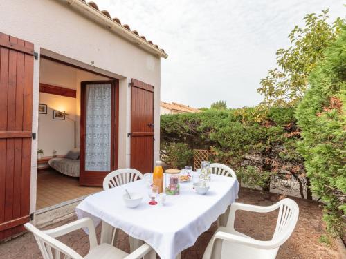 a table and chairs on the patio of a house at Holiday Home Les Charmilles-10 by Interhome in Les Mathes