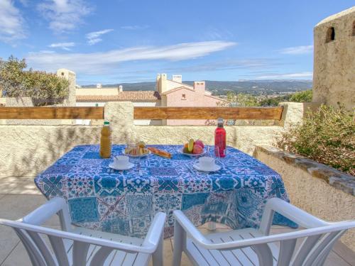 une table avec un chiffon de table bleu et blanc sur un balcon dans l'établissement Apartment Hameau la Madrague-8 by Interhome, à La Madrague