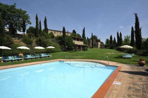 a large swimming pool with chairs and umbrellas at Hotel Borgo Casabianca in Serre di Rapolano