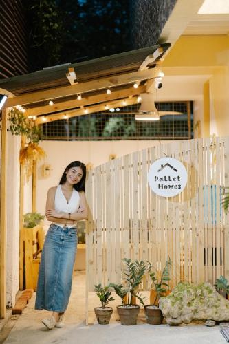 a woman standing in front of a fence at Pallet Homes - Petalsville in Iloilo City