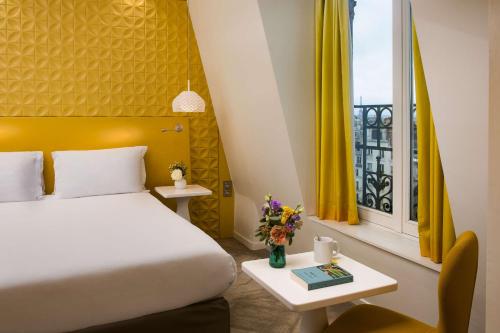 Schlafzimmer mit einem Bett und einem Fenster mit gelben Vorhängen in der Unterkunft NH Paris Gare de l'Est in Paris