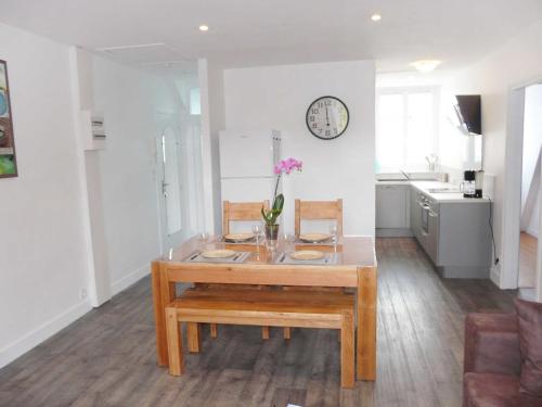 une table à manger avec deux chaises et une horloge murale dans l'établissement Apartment Pierre Legavre by Interhome, à Saint-Malo