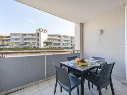une salle à manger avec une table et des chaises sur un balcon dans l'établissement Apartment Beau Rivage-2 by Interhome, à Cavalaire-sur-Mer