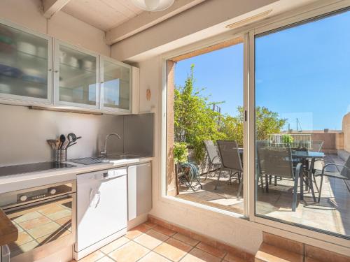 - une cuisine avec vue sur une terrasse dotée d'une table dans l'établissement Apartment Port de la Gavine I-2 by Interhome, à Hyères