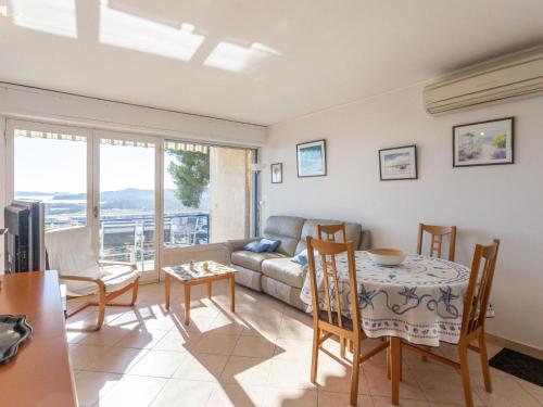 un salon avec un canapé, une table et des chaises dans l'établissement Apartment Les Alizées by Interhome, au Lavandou