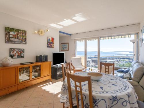 un salon avec une table et une télévision dans l'établissement Apartment Les Alizées by Interhome, au Lavandou