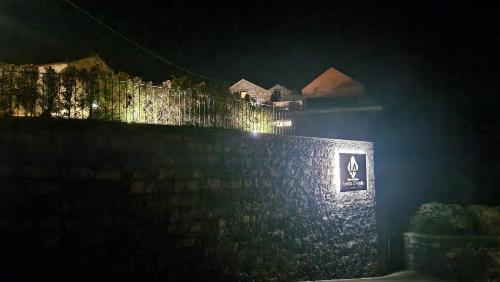 Casas de Campo Lomba D' Água - Turismo Rural في Candelária: جدار حجري عليه انوار في الليل
