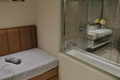 a bathroom with a shower and a sink and a tub at Dorsett Residences Hartamas in Kuala Lumpur