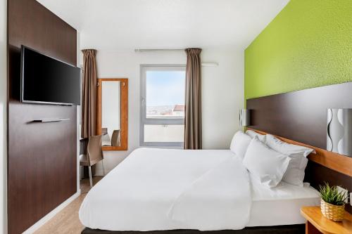 a hotel room with a bed and a tv at Première Classe Lyon Centre Gare Part Dieu in Lyon