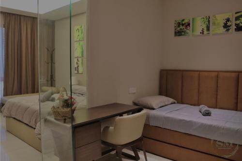 クアラルンプールにあるDorsett Residences Hartamasの机とベッドと机のある寝室と