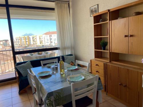 une salle à manger avec une table et des chaises et une fenêtre dans l'établissement Apartment Les Saladelles-8 by Interhome, au Grau-du-Roi