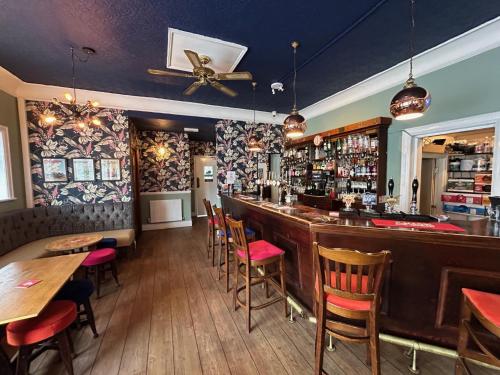 un bar en un restaurante con mesas y sillas de madera en Blue Boar Inn en Atherstone