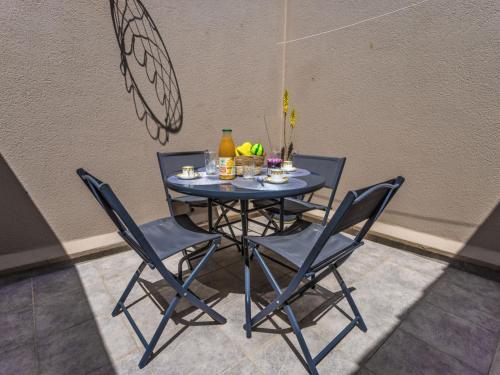une table avec deux chaises et une table avec des boissons dans l'établissement Apartment Le Pharo-6 by Interhome, au Cap d'Agde