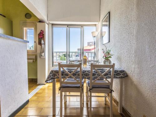 une salle à manger avec une table et des chaises et une fenêtre dans l'établissement Apartment Le Pharo-6 by Interhome, au Cap d'Agde