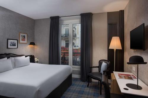 a hotel room with a bed and a desk and a window at NH Paris Opéra Faubourg in Paris