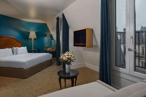 Habitación de hotel con cama y TV en NH Paris Opéra Faubourg en París