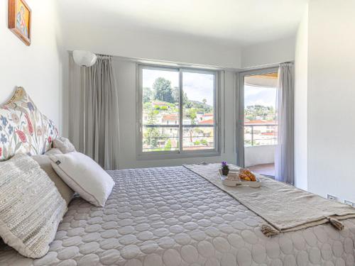 une chambre avec un grand lit avec une grande fenêtre dans l'établissement Apartment L'Antonia by Interhome, à Roquebrune-Cap-Martin