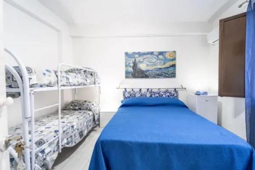 a bedroom with a blue bed and bunk beds at Charming House in Castellammare del Golfo with Balcony in Castellammare del Golfo