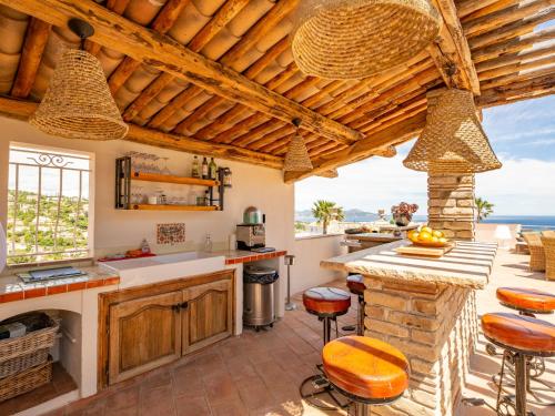 une cuisine extérieure avec des plafonds en bois et un comptoir avec des tabourets dans l'établissement Villa Boucheron by Interhome, à Roquebrune-sur Argens