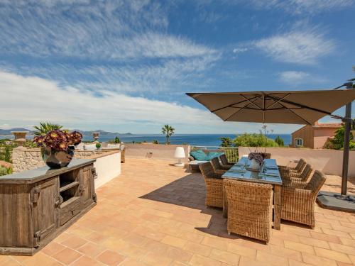 un patio avec une table, des chaises et un parasol dans l'établissement Villa Boucheron by Interhome, à Roquebrune-sur Argens