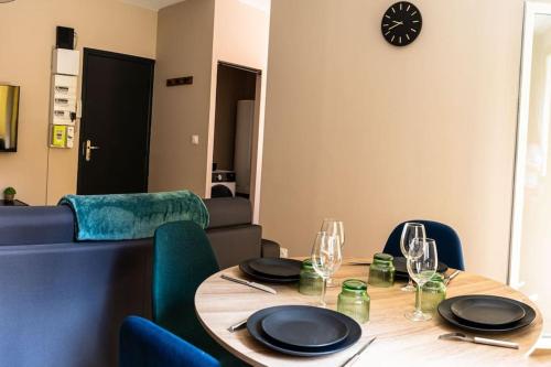 une table de salle à manger avec des assiettes et des verres dessus dans l'établissement Joli Appart deux pièces climatisé à 300m du théâtre Antique, à Orange