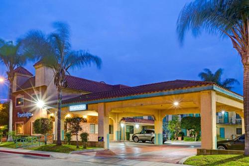 a hotel with a parking lot at night at Travelodge by Wyndham Lynwood in Lynwood
