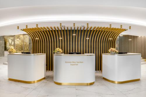 a lobby with three counters with flowers on them at Kenese Bay Garden Resort & Conference in Balatonkenese