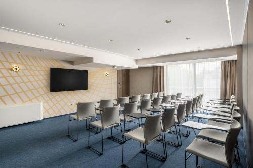 a conference room with chairs and a flat screen tv at Kenese Bay Garden Resort & Conference in Balatonkenese