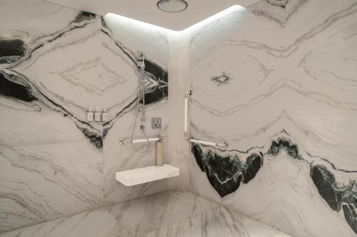 a bathroom with a marble wall with a sink at W Xiamen-Next to shopping center&Exhibition Center in Xiamen