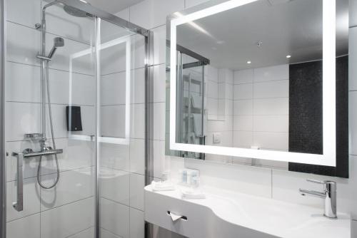 a bathroom with a shower and a sink and a mirror at Thon Hotel Rosenkrantz Oslo in Oslo