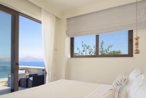 a bedroom with a bed and a view of the ocean at Miraida Exclusive Residence in Almirida