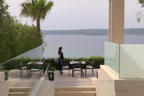 a woman standing on a patio looking out at the water at Miraida Exclusive Residence in Almirida