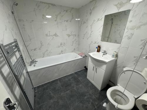 y baño con aseo, bañera y lavamanos. en A&K Inn, en Bournemouth