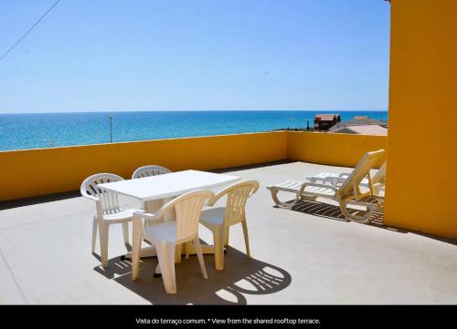 a table and chairs on a balcony with the ocean at Blife Faro Beach Hostel & Rooms in Faro