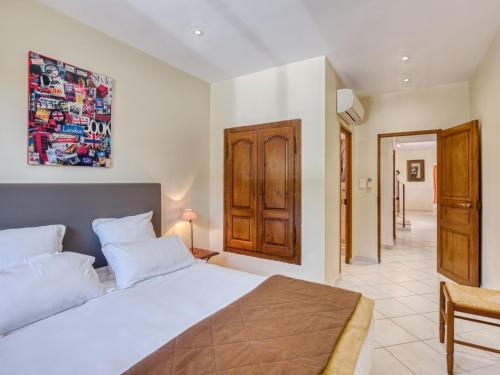 une chambre avec un lit blanc et une armoire en bois dans l'établissement Villa Villa I Tre Fratelli by Interhome, à Pianottoli-Caldarello