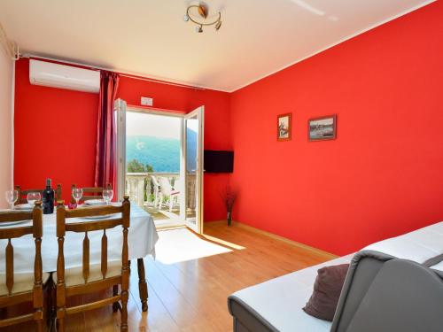 a living room with red walls and a dining room table at Apartment Miro-1 by Interhome in Grebaštica