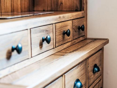 a wooden dresser with black knobs and pulls at Holiday Home Old Stables by Interhome in Drumnadrochit