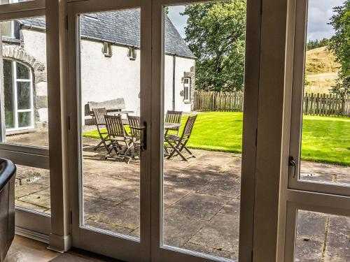 an open door to a patio with a table and chairs at Holiday Home Old Stables by Interhome in Drumnadrochit