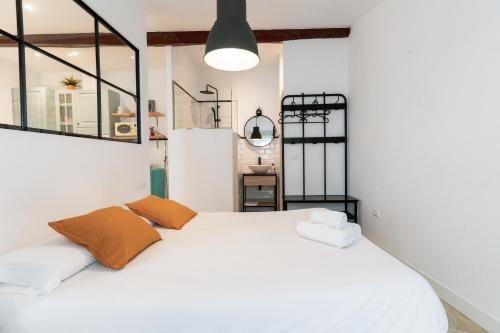 a bedroom with a white bed with two pillows at Loft Alguer en Ametlla de Mar in L'Ametlla de Mar