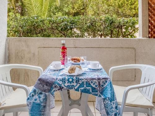 une table avec un chiffon de table bleu et blanc et une bouteille dans l'établissement Apartment Super Plage-1 by Interhome, à Saint-Cyr-sur-Mer