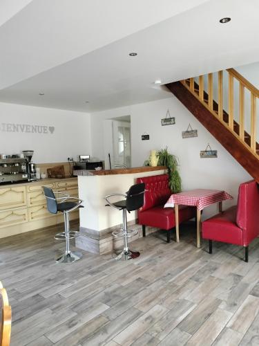 a bar with red chairs and a counter in a room at Chambre d'hôtes l'orchidée in Voutré
