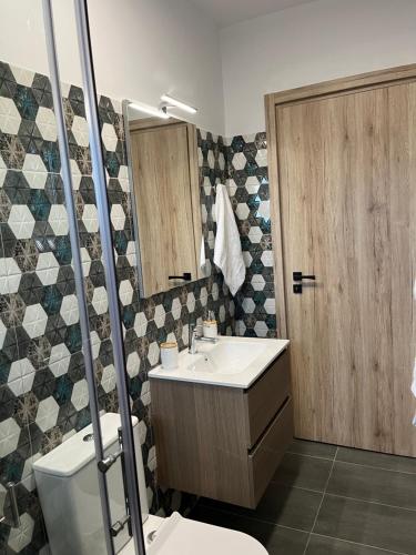 a bathroom with a sink and a toilet and a mirror at faskomilo house 2 in Faskomiliá