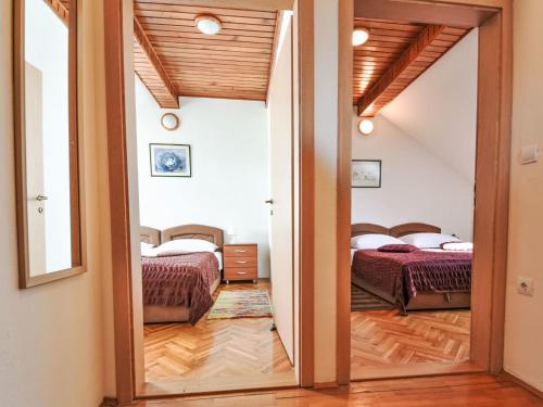Una habitación con dos camas y una puerta que conduce a un dormitorio. en Apartment Bastaja Rastoke by Interhome, en Slunj