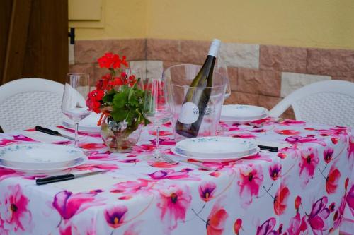une table avec un tissu de table blanc et des fleurs roses dans l'établissement Casa Paola 300m Con Vista Mare, à Costa Rei