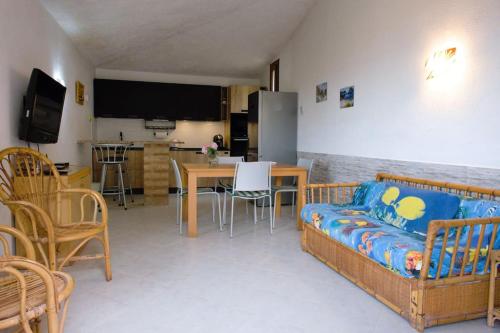 un salon avec un canapé et une table avec des chaises dans l'établissement Casa Paola 300m Con Vista Mare, à Costa Rei